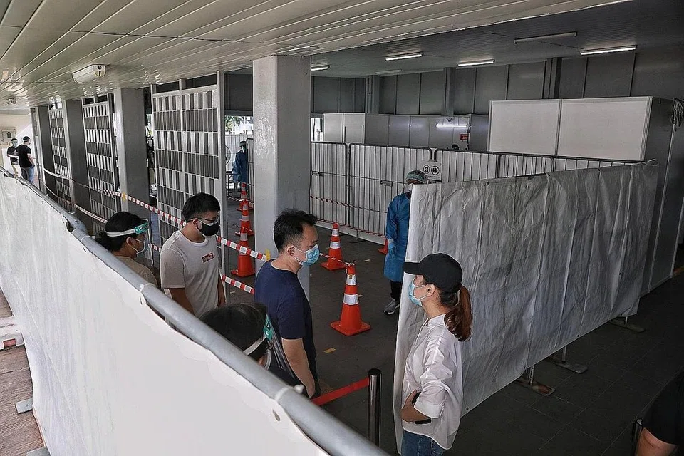 DIUJI: Penduduk tiba di kawasan serbaguna bersebelahan Blok 325A Sumang Walk semalam untuk menjalani ujian swab. - Foto KEVIN LIM