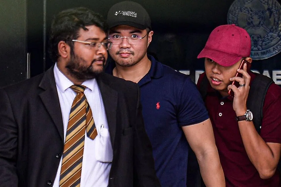 DAKWA MENTERI: Encik Haziq Aziz (tengah) dirakam meninggalkan balai polis Dang Wangi di Kuala Lumpur Sabtu lalu. - Foto EPA-EFE 