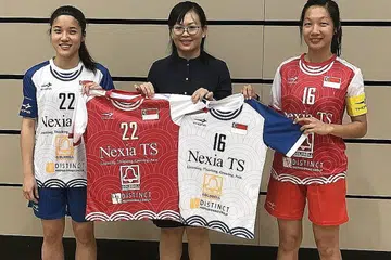 TAJAAN BERMAKNA: Pasukan floorball wanita negara menunjukkan jersi pasukan yang memaparkan penaja utama, Nexia TS. Kelihatan kapten pasukan Amanda Yeap (jersi no. 22), naib kapten Jowie Tan (jersi no. 16), dan diantara mereka, Cik Loh Hui Nee, pengarah Nexia TS, yang telah menaja pasukan wanita sejak 2017. - Foto fail