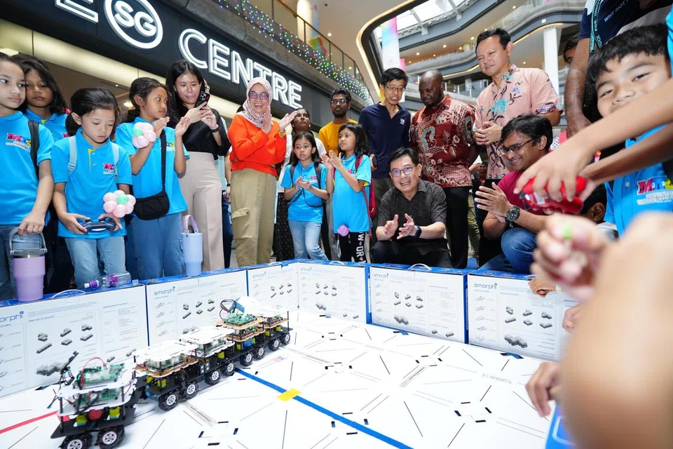 Timbalan Perdana Menteri, Encik Heng Swee Keat (duduk, berbaju hitam) berkunjung ke sebuah reruai yang mempamerkan kebolehan robotik di acara  Raikan Ilmu@Heartlands 2024 anjuran Yayasan Mendaki di Our Tampines Hub (OTH) pada 29 Jun. Beliau diiringi Menteri Negara Kanan (Pertahanan merangkap Tenaga Manusia), Encik Zaqy Mohamad (berdiri, kanan) dan Ketua Pegawai Eksekutif (CEO) Mendaki, Cik Zuraidah Abdullah (enam dari kiri). 