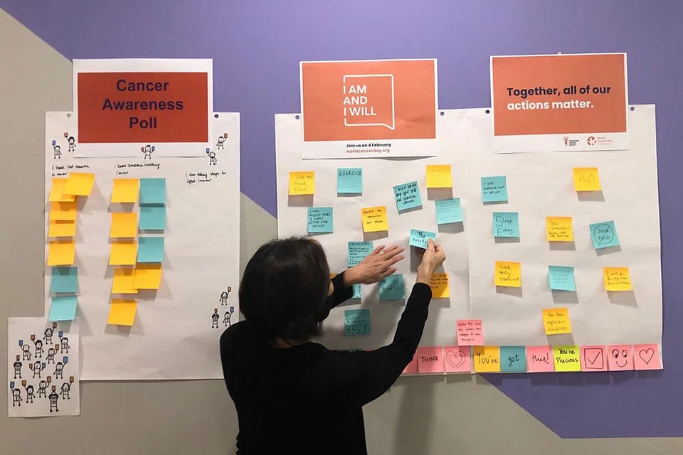 BUKAN ISU LARANGAN: Bagi menggalak kakitangannya bebas berbual tentang barah, Pusat Sukarelawan dan Dermawan Nasional (NVPC) menggalak mereka menulis di papan tanda ikrar dan tinjauan yang mencetus kesedaran tentang penyakit barah sempena Hari Barah Sedunia hari ini. - Foto PERSATUAN BARAH SINGAPURA