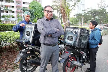 MASUKI PASARAN: Pengasas firma Halal Food Truck Encik Mohd Sufian Sa'i bersama dua pengirim makanannya mahu memanfaatkan teknologi demi mengatasi isu makanan tiba lewat. - Foto BH oleh JONATHAN CHOO
