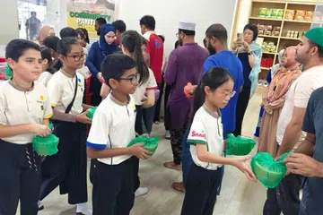 Pelajar Sekolah Rendah FuHua ketika menyertai program agihan bubur Ramadan kepada jemaah Masjid Hasanah untuk memupuk nilai prihatin sempena Ramadan 2025.