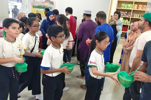 Pelajar Sekolah Rendah FuHua ketika menyertai program agihan bubur Ramadan kepada jemaah Masjid Hasanah untuk memupuk nilai prihatin sempena Ramadan 2025.