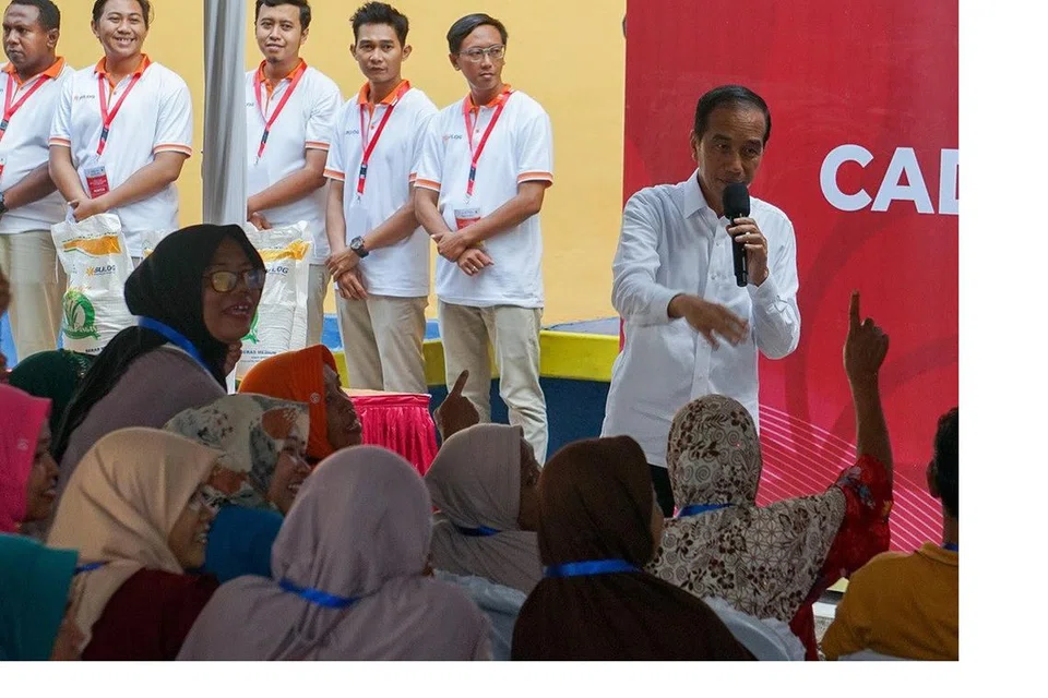 Presiden Joko ‘Jokowi’ Widodo (kanan) bercakap dengan penduduk Pekalongan, Jawa Tengah, semasa lawatan kerjanya ke bandar itu pada 13 Disember 2023 untuk memeriksa gudang Agensi Logistik Negeri (Bulog) yang berhampiran. Dalam lawatan itu, Presiden Jokowi secara simbolik mengagihkan 10,000 kilogram beras kepada 1,000 keluarga. 