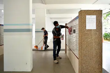 JALANI SWAB:(atas) Penduduk di blok 506 Hougang Ave 8 menjalani ujian swab yang wajib sementara pekerja pembersihan menjalankan usaha menyahjangkit kotak surat di kolong blok 506 Hougang Ave 8 semalam. -Foto BH oleh LIM YAOHUI