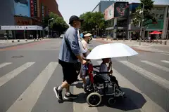 PANAS MENYENGAT: Seorang pejalan kaki menyeberangi jalan di bawah panahan terik matahari di tengah-tengah amaran gelombang panas melanda Beijing, China. 