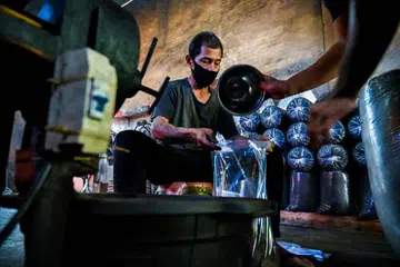 Kegiatan ‘ngopi’, atau menghirup kopi, yang rancak di Banda Aceh mencerminkan ekonominya yang terus berkembang. Gambar menunjukkan  pekerja sibuk membungkus biji kopi jenis robusta yang telah siap dipanggang menerusi kaedah tradisional Aceh di Krueng Baroja Jaya, di pinggir Banda Aceh.