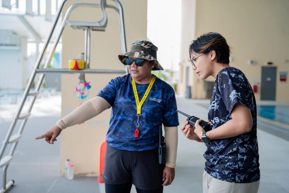 JALANKAN TUGAS: Farhanah Ruhaizat (kanan) memeriksa kolam renang di tempat kerja bersama seorang penyelamat. 