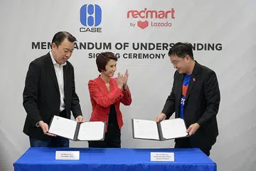 RASMI KERJASAMA: Presiden Case, Encik Melvin Yong (kiri) dan Ketua Pegawai Eksekutif Lazada Singapore, Encik Loh Wee Lee, menandatangani MOU sambil disaksikan Menteri Negara (Perdagangan dan Perusahaan), Cik Low Yen Ling semalam. - Foto BH oleh NG SOR LUAN
