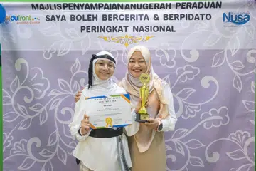 Johan Kategori C ‘Saya Boleh Bercerita’, Nayla Zafirah Rozaini (kiri), bergambar bersama ibunya, Cik Nurwani Yacob.