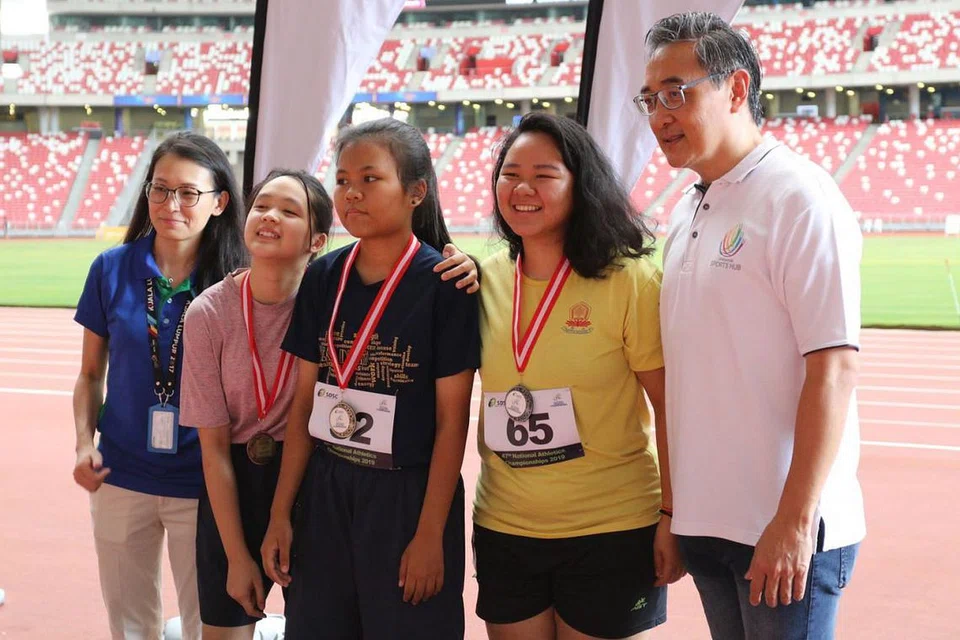 TAHNIAH PEMENANG! Tetamu terhormat kejohanan, CEO Hab Sukan Singapura, Oon Jin Teik (kanan) dan pengarah eksekutif SDSC, Cik Kelly Fan (kiri), bergambar dengan pemenang acara perlumbaan 800 meter T20 - pemenang pingat emas, Nurnabila Abdullah dari Sekolah Senior Delta (tengah), pemenang pingat perak Sunandi Gurung dari Sekolah Metta (dua dari kanan) dan pemenang gangsa Rachel Tan, juga dari Sekolah Metta. 