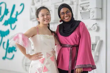 SALUR BAKTI: Cik Nurain Mohd Hussain (kanan) memanfaatkan kemahiran menjahit dan mengait yang diraih daripada kursus di Politeknik Temasek bagi menghasilkan gaun untuk diperagakan remaja disleksia, Isabelle Wong di acara Singapore Fashion Runway di OCBC Square, Hab Sukan Singapura, esok. - Foto POLITEKNIK TEMASEK
