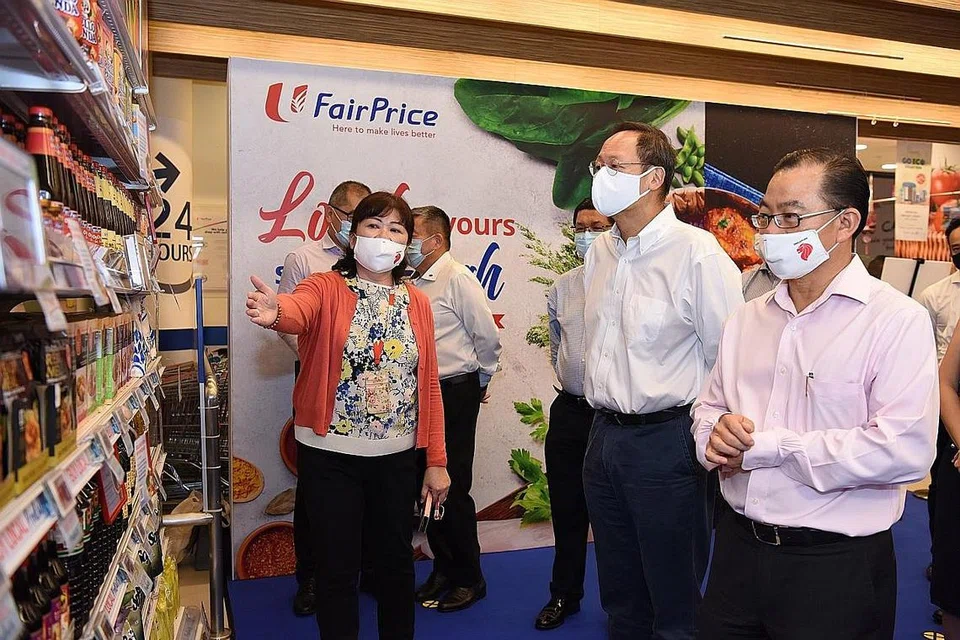 HADIRI PAMERAN: Menteri Kedua Tenaga Manusia merangkap Menteri Kedua Perdagangan dan Perusahaan, Dr Tan See Leng (dua dari kanan), dan CEO FairPrice Group, Encik Seah Kian Peng (paling kanan), di majlis pelancaran pameran 'Made in Singapore'. - Foto NTUC FAIRPRICE