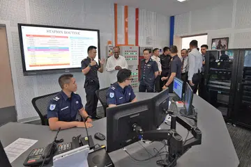 WADAH UNTUK BERGABUNG: Encik Shanmugam (baju putih) mengunjungi Pusat Bersama Home Team di Balai Bomba Kallang semasa pelancarannya semalam. - Foto BH oleh ALPHONSUS CHERN