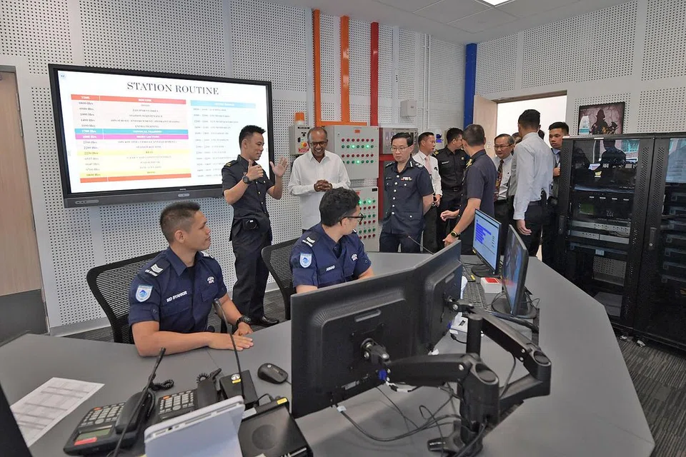WADAH UNTUK BERGABUNG: Encik Shanmugam (baju putih) mengunjungi Pusat Bersama Home Team di Balai Bomba Kallang semasa pelancarannya semalam. - Foto BH oleh ALPHONSUS CHERN
