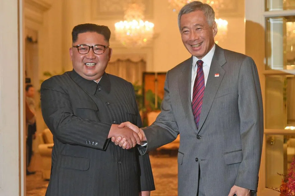 TEMU MESRA: Encik Kim Jong Un (kiri) disambut Encik Lee di Istana petang semalam sejurus tiba di sini semalam. - Foto AFP