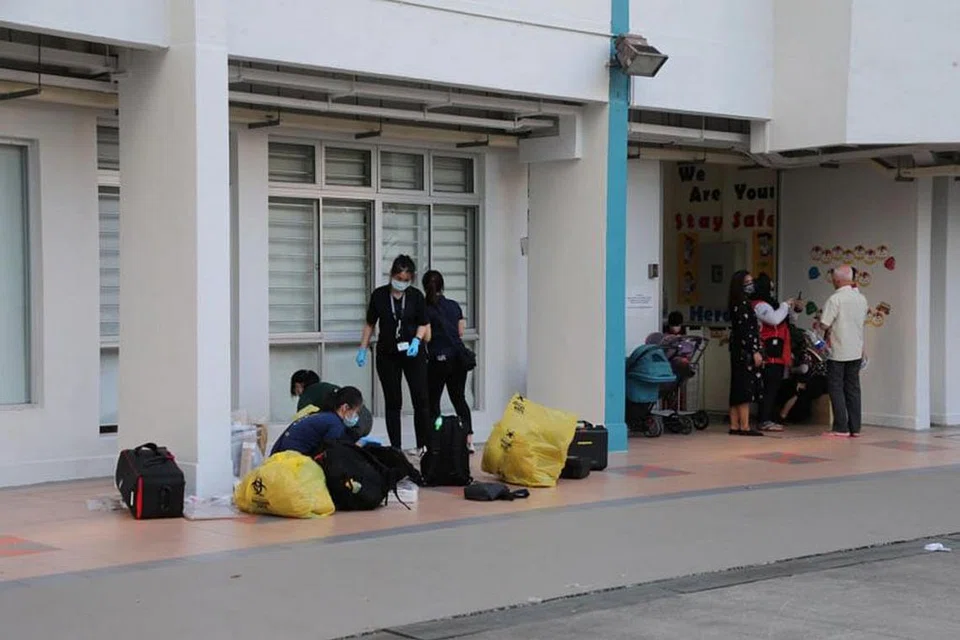 DI TEMPAT KEJADIAN: Pegawai polis di kawasan kolong Blok 308, Jurong East Street 32 semalam di mana seorang wanita telah ditemui terbaring tidak bergerak dengan beberapa kesan tusukan di tubuhnya. - Foto LIANHE ZAOBAO