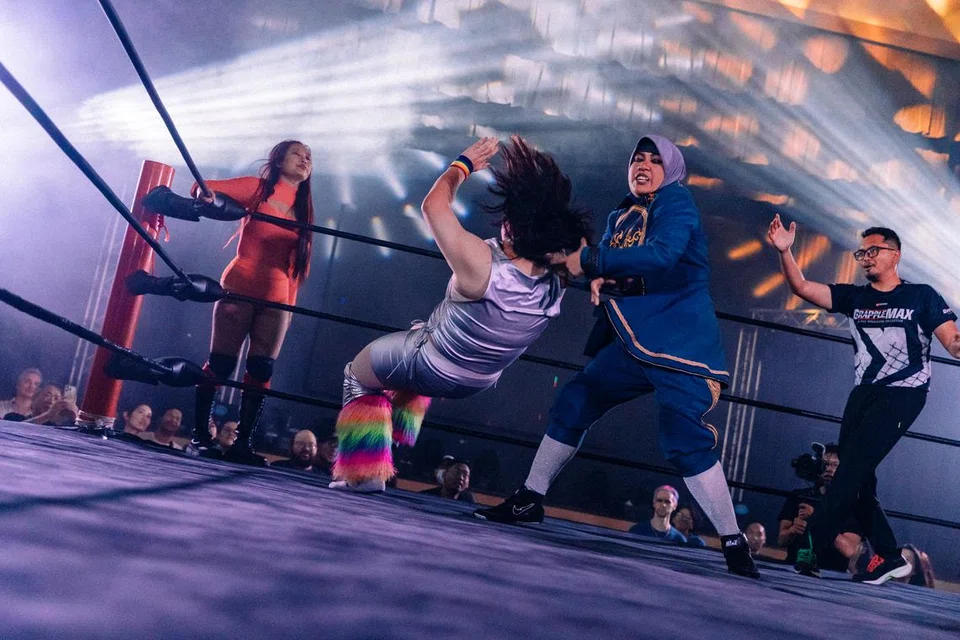 Cik Maisarah Abu Samah (dua dari kanan) bersaing dengan Ming Rui, ahli gusti profesional terkemuka di Singapura, dalam acara Pro Wrestling Festival pada November lalu.