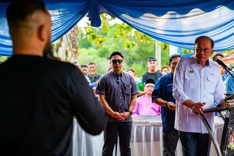 Perdana Menteri Malaysia, Datuk Seri Anwar Ibrahim (kanan), ketika mendengar cadangan daripada seorang nelayan, pada  majlis minum petang bersama nelayan, petani dan penduduk di Pantai Leka, Parit Jawa, Muar.