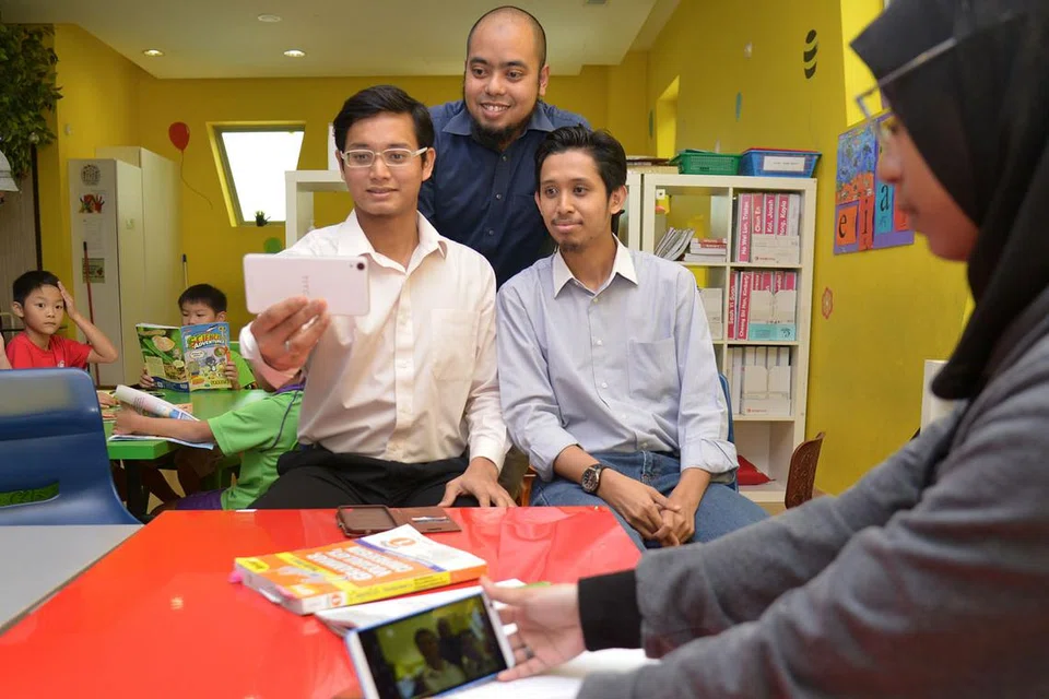 TEROKA DIGITAL: (Dari kanan) Encik Muhammad Mohamed Rahim, Encik Salihin Mohamed Rahim dan Encik Muhammad Taufik Yahya (berdiri) merancang meluaskan aplikasi mereka ke pasaran serantau. Buat masa ini, aplikasi itu sudah menarik perhatian pengguna dari Indonesia. - Foto fail