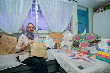 KOLEKSI LAYANG-LAYANG: Cik Gadis Widiyati menunjukkan koleksi layang-layang tradisional dari seluruh dunia yang dimilikinya, termasuk dari Malaysia dan Jepun. Setiausaha Persatuan Layang-Layang Singapura (SKA) itu giat membantu menganjurkan kegiatan terbang layang-layang untuk penggemar layang-layang di dalam dan luar negara serta mengadakan bengkel membuat layang-layang.