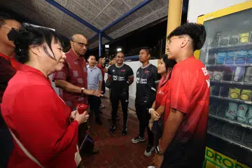 RAIH MANFAAT:  Pasangan adik-beradik, (dari kanan) Nadir Umair Mohd Shaiful dan Nabilah Atiqah Mohd Shaiful berbual dengan Presiden Tharman Shanmugaratnam (dua dari kiri) dan isterinya, Cik Jane Ittogi (kiri), di acara menyambut ulang tahun ke-10 program bola sepak, ‘Saturday Night Lights’, di Stadium Woodlands pada 18 November.