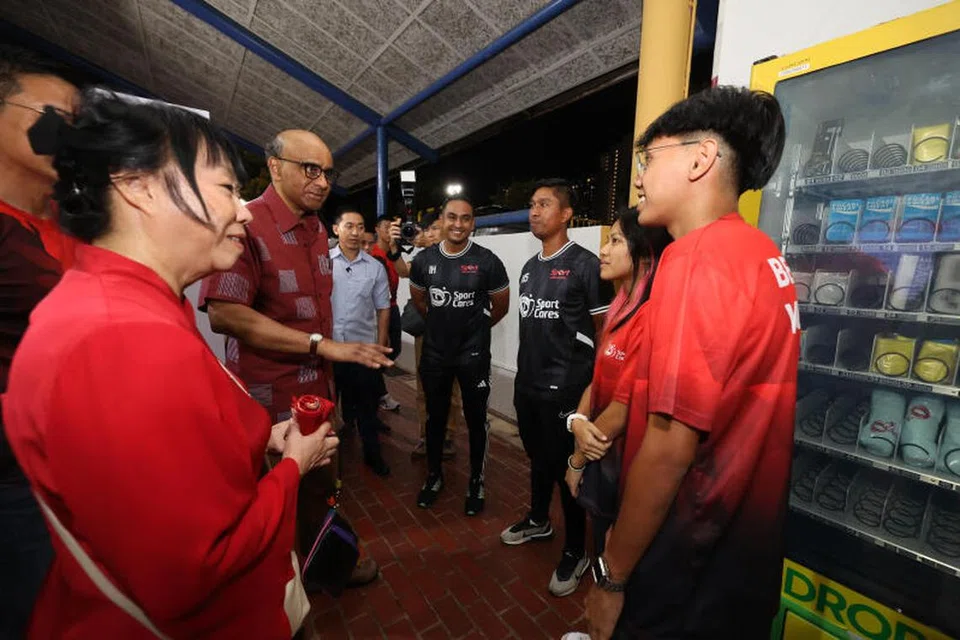 RAIH MANFAAT:  Pasangan adik-beradik, (dari kanan) Nadir Umair Mohd Shaiful dan Nabilah Atiqah Mohd Shaiful berbual dengan Presiden Tharman Shanmugaratnam (dua dari kiri) dan isterinya, Cik Jane Ittogi (kiri), di acara menyambut ulang tahun ke-10 program bola sepak, ‘Saturday Night Lights’, di Stadium Woodlands pada 18 November.
