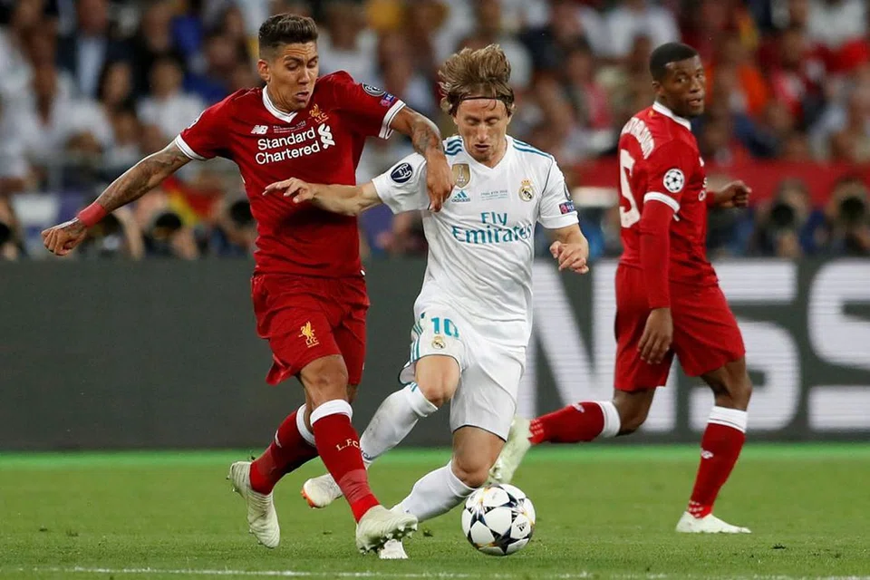 MAIN DI PADANG SENDIRI: Pemain Liverpool Roberto Firminho (kiri) beraksi bersama Luka Modric dari Real Madrid (kanan)dalam perlawanan di Kiev, Ukraine pada Mei 2018. - Foto REUTERS