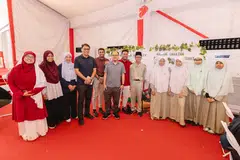 Pelajar Madrasah Al-Arabiah Al-Islamiah bersama Ketua Eksekutif MUIS, Encik Kadir Maideen (empat dari kiri), mempamerkan kegiatan menghasilkan alas cawan daripada fabrik kitar semula, sekali gus menggalakkan amalan kelestarian melalui penggunaan semula fabrik daripada pakaian terpakai.