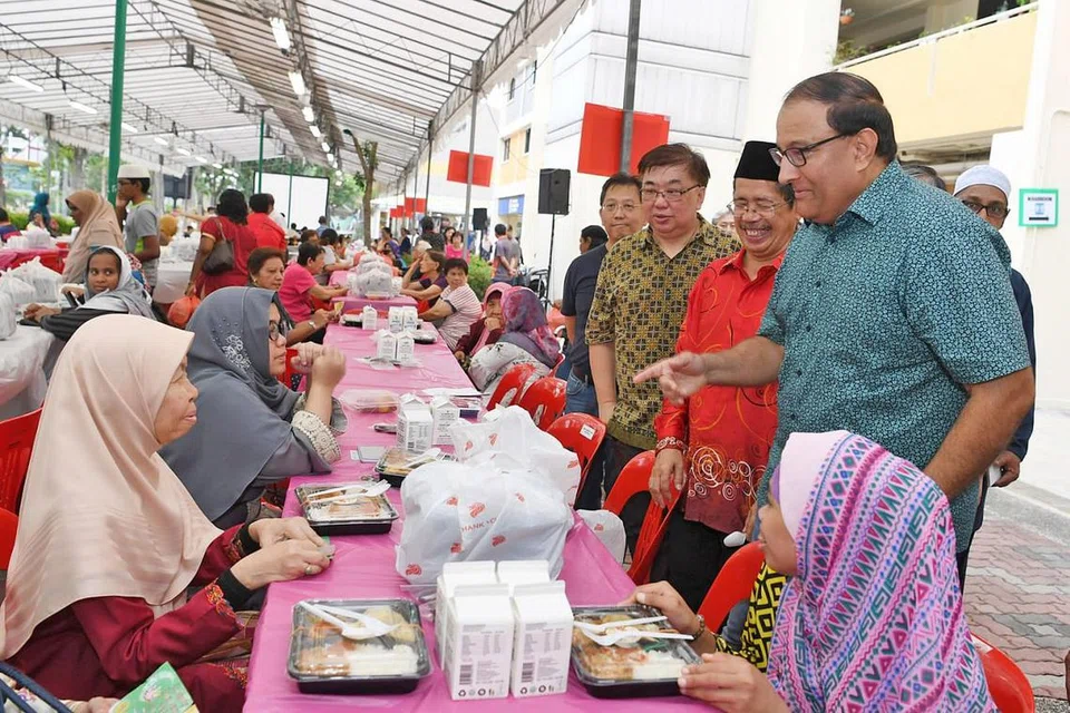 BERAMAH MESRA: Encik S. Iswaran (berdiri di kanan) yang turut ditemani Timbalan Pengerusi (MAEC)Kelab Masyarakat West Coast, Encik Rosali Buang (berdiri dua dari kanan) beramah mesra dengan penduduk kejiranan West Coast yang menghadiri sesi berbuka puasa di Clementi West Street 2 semalam. - Foto BM oleh KHALID BABA