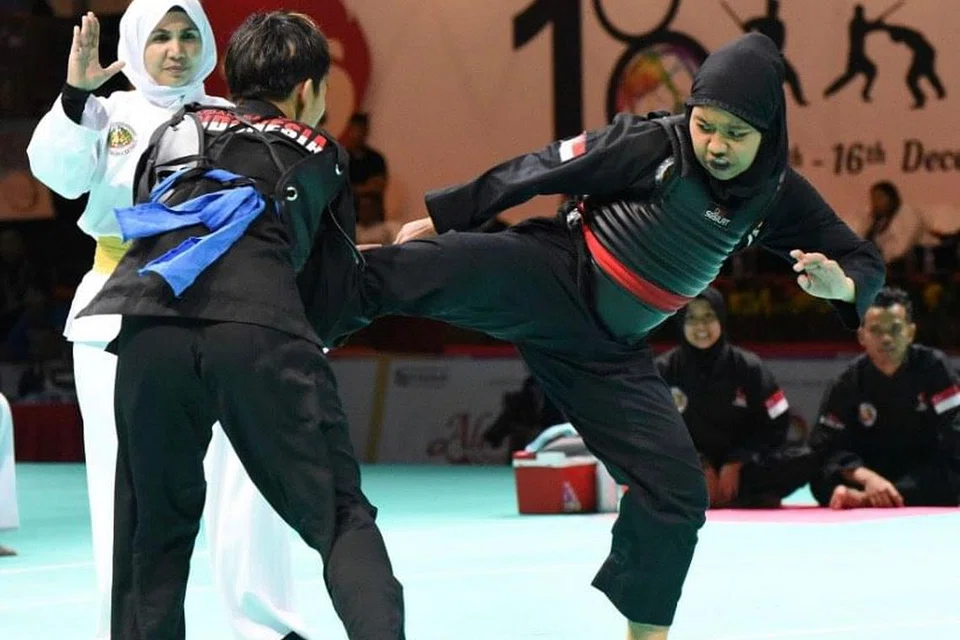 TEPAT PADA SASARAN: Nur Syaza Insyirah Md Roslan (kanan) memberikan saingan yang sengit kepada pesilat Indonesia, Nimalasari Octaviani dalam pertarungan Kelas B yang dimenangi pesilat Singapura itu 3-2.