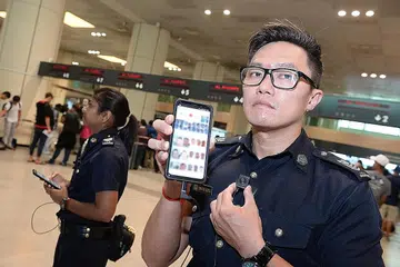LEBIH CEKAP: Alat mudah alih yang mempunyai keupayaan ABBSS digunakan pegawai ronda dan ia dapat mengesan mereka yang dicari penguasa sebelum mereka tiba di kaunter imigresen. - Foto SPH