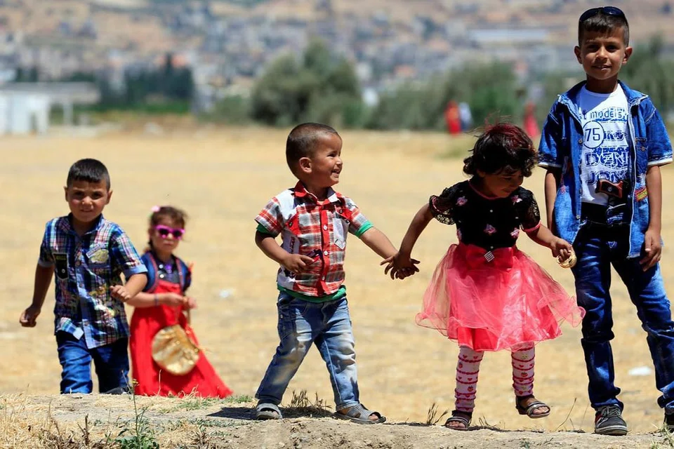 DI LEBANON: Kanak-kanak Syria yang berlindung di khemah pelarian di kampung Delhemiyeh dekat Lebanon menyambut Raya dengan pakaian berwarna-warni. - Foto REUTERS