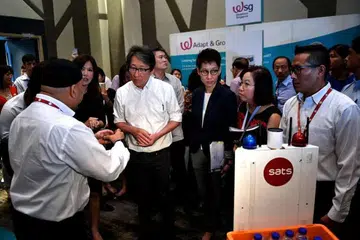 Sebuah kenderaan bergerak sendiri (AGV) dari Sats menunjukkan jalan kepada Menteri Tenaga Manusia Lim Swee Say semasa pameran kerjaya di Hotel Crowne Plaza di Lapangan Terbang Changi pada 8 Feb 2017. 