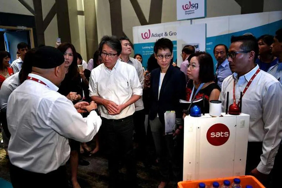 Sebuah kenderaan bergerak sendiri (AGV) dari Sats menunjukkan jalan kepada Menteri Tenaga Manusia Lim Swee Say semasa pameran kerjaya di Hotel Crowne Plaza di Lapangan Terbang Changi pada 8 Feb 2017. 