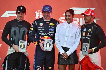 Juara perlumbaan pecut Max Verstappen (dua dari kiri) bergambar bersama pemenang tempat ketiga Charles Leclerc (kiri) dan naib juara, Lewis Hamilton (kanan). Mereka telah menerima trofi masing-masing daripada ratu pecut Singapura, Shanti Pereira (dua dari kanan) sejurus selepas perlumbaan pecut berakhir di Litar Marina Bay.