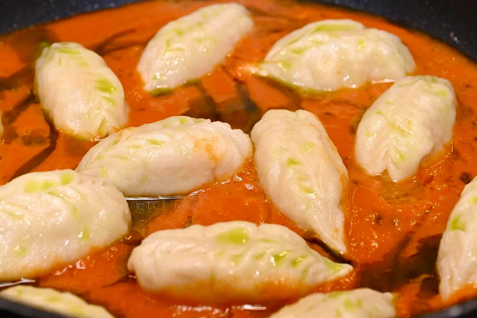 Pasta Culurgiones diisi dengan kentang dan pudina bersama sos tomato dan minyak selasih.