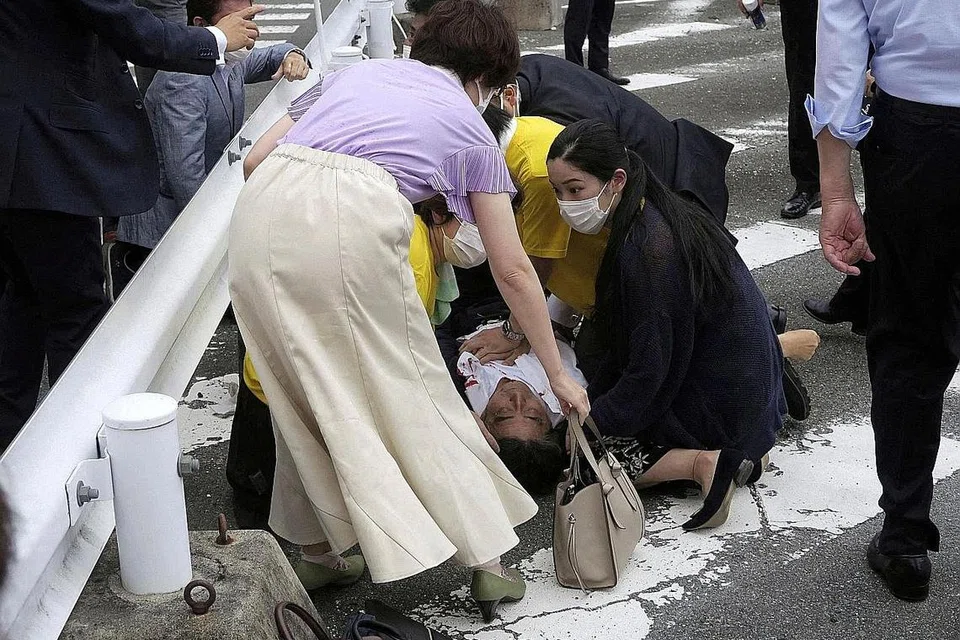 DITEMBAK: Bekas perdana menteri Jepun Encik Shinzo Abe terbaring di atas jalan raya selepas ditembak semasa mengadakan kempen pilihan raya di Nara, barat Jepun. - Foto-foto Reuters