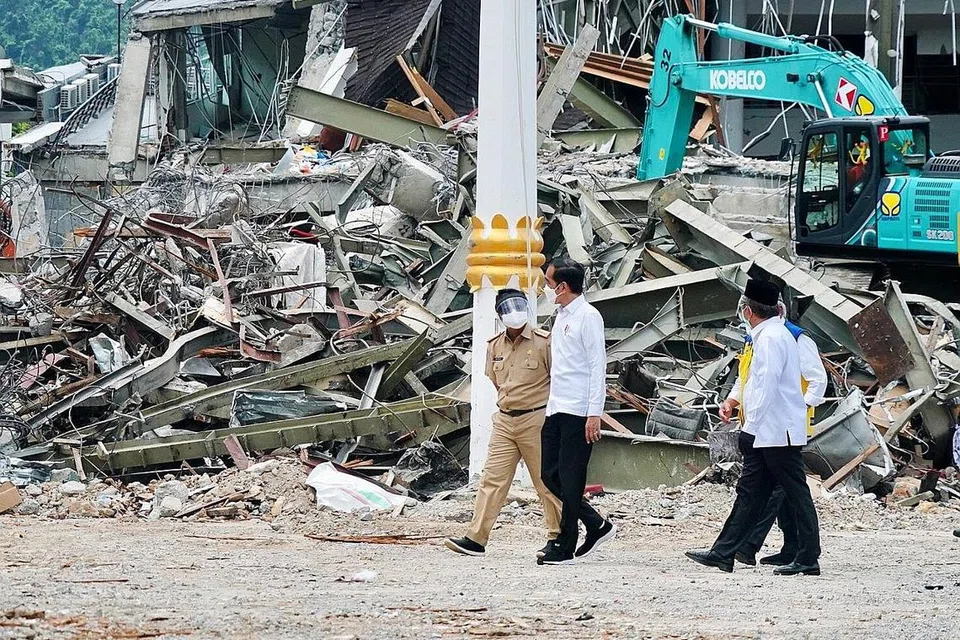 LAWATAN KE TAPAK NAHAS: Presiden Indonesia, Encik Joko Widodo (dua dari kiri), melawat bandar Mamuju, Sulawesi Barat, kelmarin bagi menemui mangsa dan menawarkan bantuan pemerintah. - Foto REUTERS
