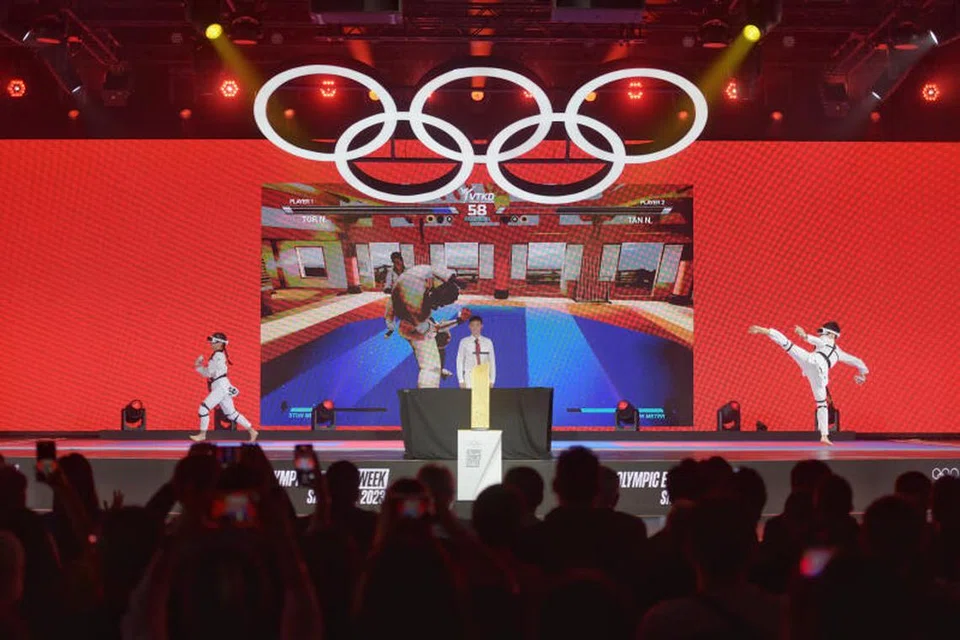 DEDAH BAKAT: Nigel Tan (kanan) memenangi acara taekwondo maya di E-Sukan Olimpik yang diadakan di Pusat Pameran dan Persidangan Suntec Singapura. 