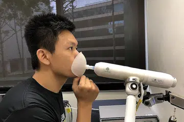 UJIAN JANGKITAN: Ketua Perisian & Perkongsian Breathonix, Encik Chan Tiong Ley, menunjukkan ujian pernafasan menerusi sistem tidak invasif dengan melekapkan mulut ke muncung Sistem Ujian Nafas BreFence Go Covid-19. - Foto BH oleh ONG WEI QIANG