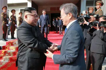 PERTEMUAN DUA PEMIMPIN: Ketua Korea Utara, Encik Kim Jong Un (kiri) berjabat tangan dengan Presiden Korea Selatan, Encik Moon Jae In, semasa pertemuan di desa kedamaian Panmunjom dalam kawasan bebas tentera di bahagian Utara. - Foto AFP