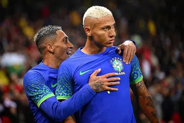 DUA PENJARING GOL JADI SASARAN PERKAUMAN: Richarlison (atas), dibaling pisang dan Neymar diganggu dengan pancaran laser semasa Brazil menentang Tunisia dalam perlawanan persahabatan di Paris. Brazil menewaskan Tunisia 5-1. - Foto REUTERS/AFP