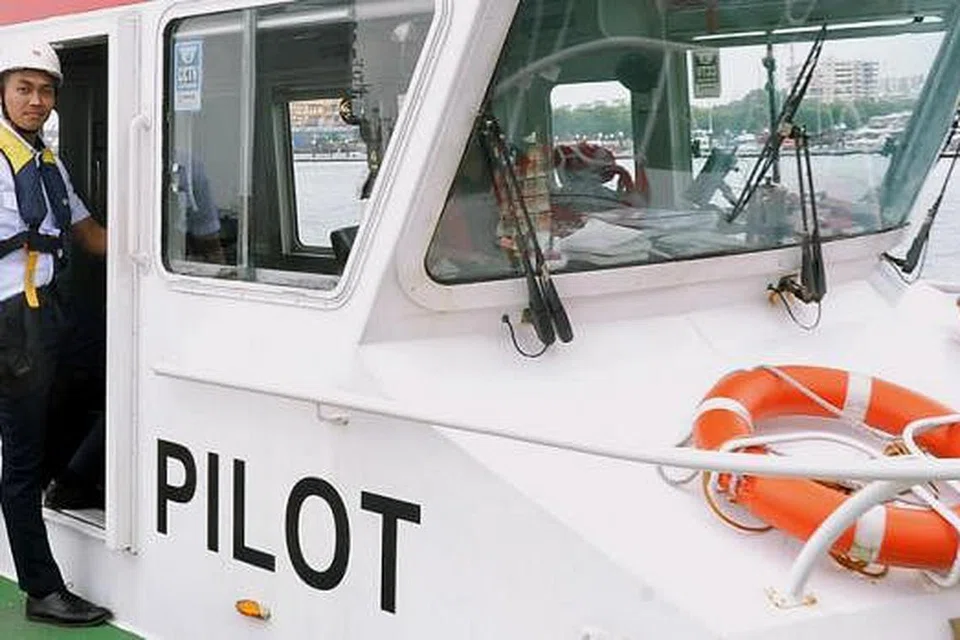 PUAS HATI PILIH KERJAYA DALAM BIDANG MARITIM: Antara rutin harian Encik Muhammad Zulhadis Zulkeplie ialah menaiki bot pilot atau jurumudi ke tengah laut dekat perairan Singapura, tempat kapal sedang menunggu. - Foto-foto KHALID BABA