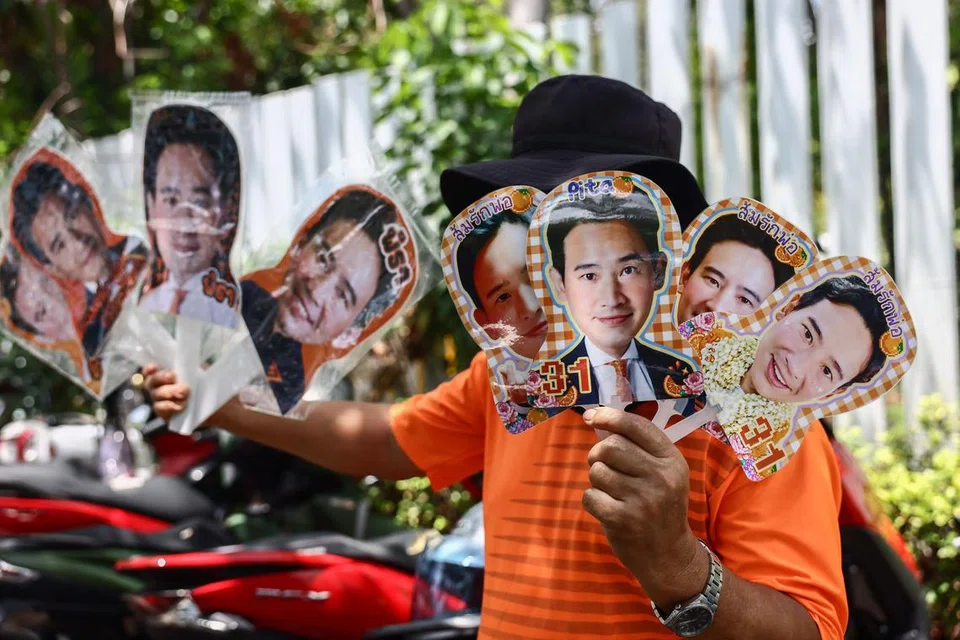 RAIH SOKONGAN:  Seorang peniaga memegang poster pemimpin parti Move Forward, Encik Pita Limjaroenrat, yang kini meraih lebih banyak sokongan untuk membentuk kerajaan Thailand yang baru.  