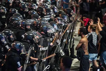 POLIS DAN PENUNJUK PERASAAN: Polis berhadapan dengan penunjuk perasaan yang bersama penduduk dan aktivis lain kulit hitam membantah kematian Encik Keith Scott yang ditembak mati oleh polis di Chartotte pada Selasa lalu. - Foto AFP