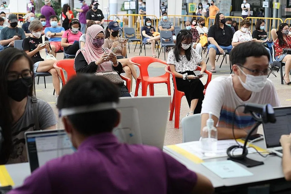 VAKSINASI PELAJAR: Pelajar Sekolah Menengah Xinmin, Lu'Lu Aliesha Samion (baju putih), ditemani ibunya, Cik Sabariah Mohd Noor (bertudung), di Pusat Vaksinasi Kelab Masyarakat Bishan. Para pelajar mula divaksinasi pada 3 Jun, dengan keutamaan diberikan kepada pelajar yang bakal tamat sekolah menengah dan pra-universiti. - Foto ZAOBAO