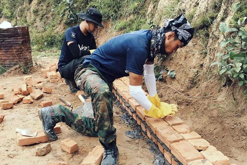 GOTONG-ROYONG: Pelajar NTU bekerjasama membina tembok untuk mengelak hakisan tanah pada musim hujan di Nepal. - Foto SYAHIRAH AFIFAH ABU BAKAR