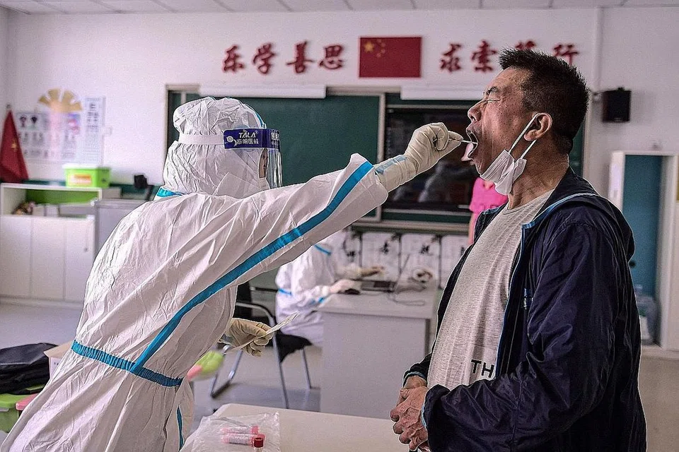 PERGIAT UJIAN: Seorang kakitangan di sebuah sekolah rendah menjalani ujian Covid-19 di Shenyang. Sehingga 12 September lalu, China mencatat 95,248 kes positif Covid-19. - Foto AFP